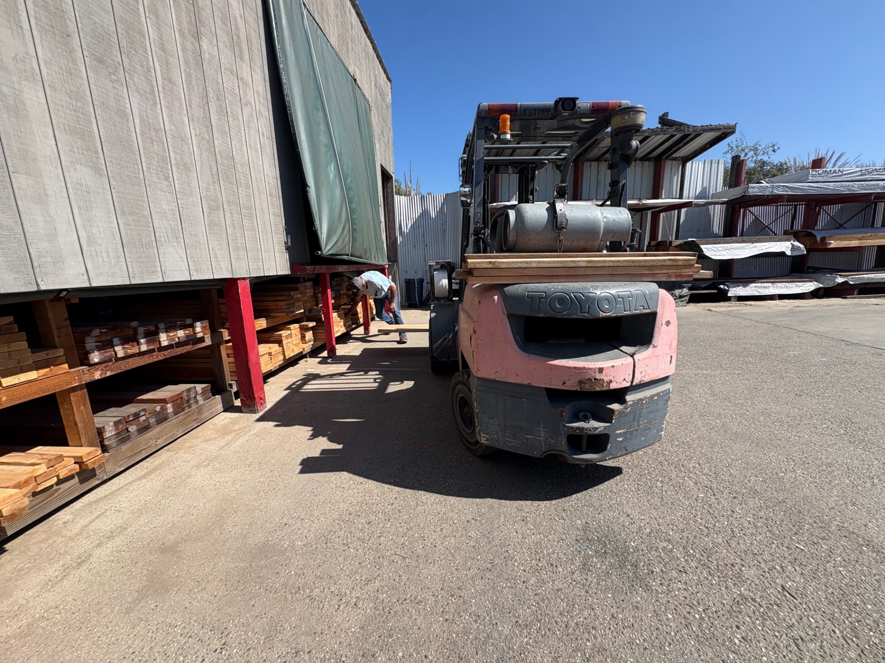 Forklift loading lumber from the covered yard racks